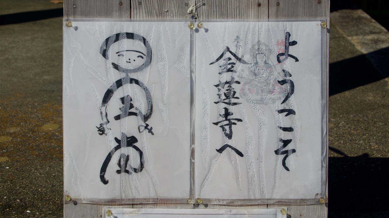 The 御朱印 temple's seal stamp. The image on the left is 国宝弥陀堂 *kokuhō midadō* \"National Treasure Amitabha Hall\" stylized to look like a smiling Amitabha Buddha.