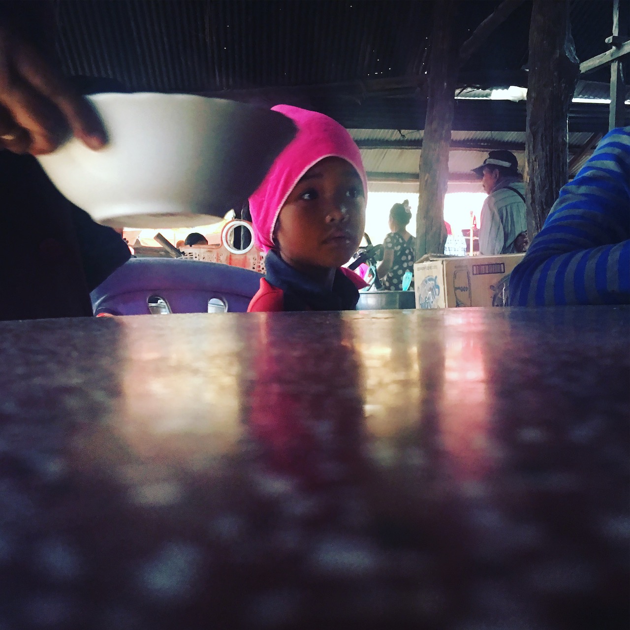 Sharing a table and having rice noodles at a country market.